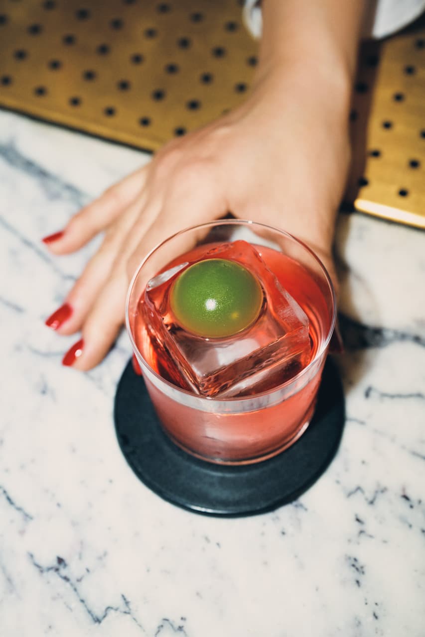 A hand holding a Negroni made by Giulia Cuccurullo