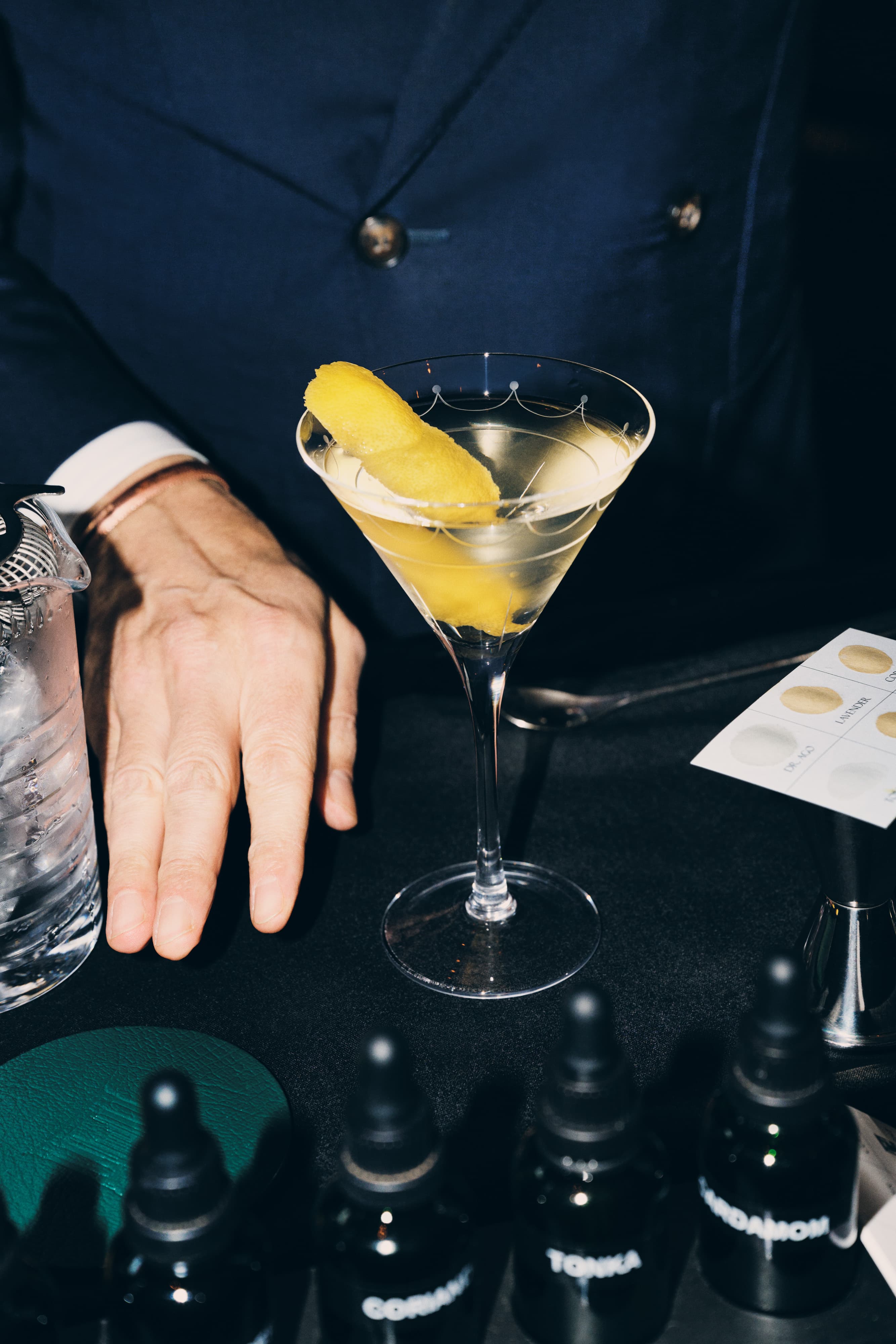 A hand next to a Connaught Martini cocktail.