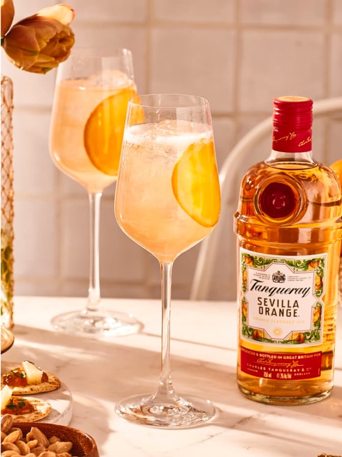 Two Gin Spritz cocktails made with Tanqueray Flor de Sevilla and garnished with orange slices.