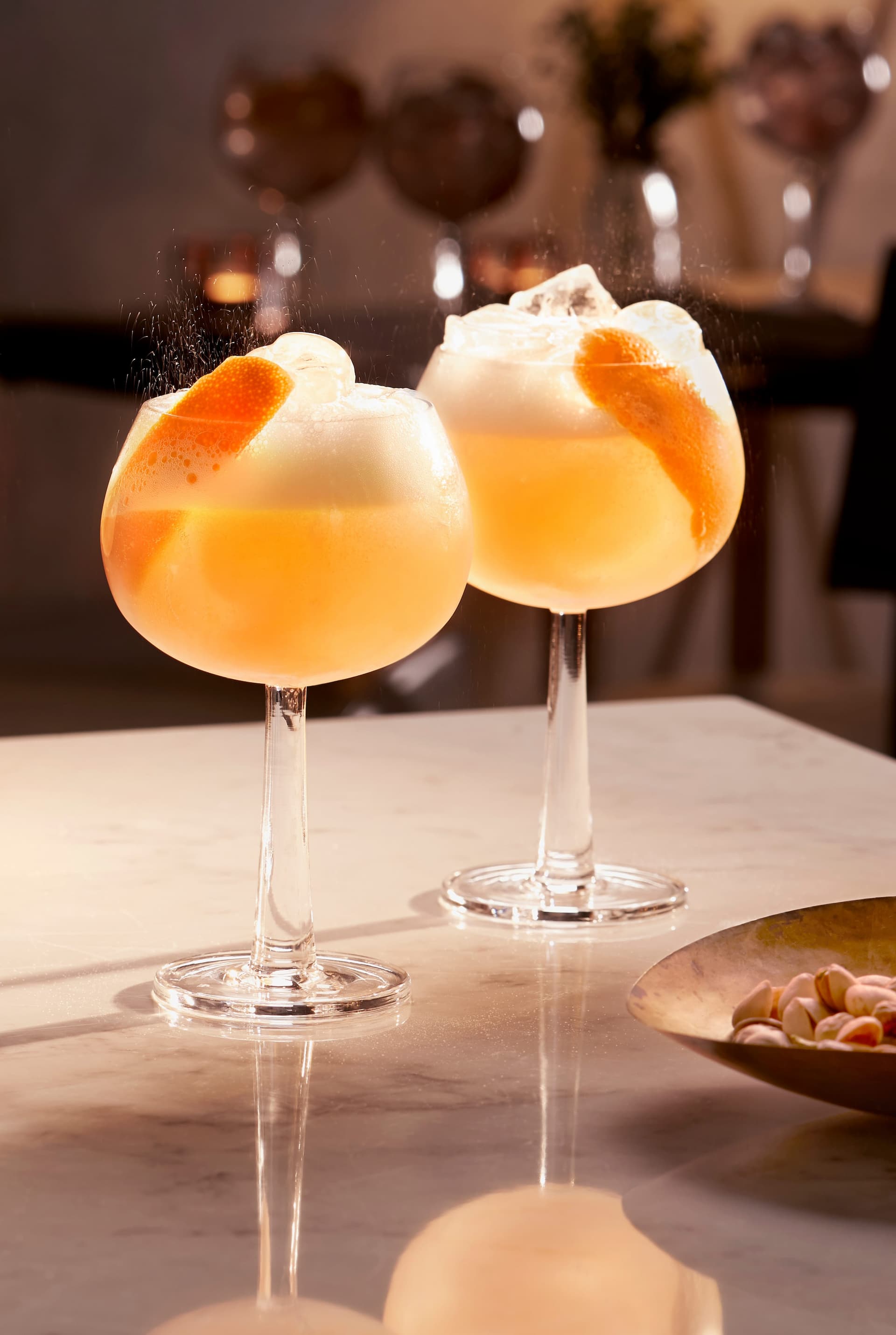 Two grapefruit spritz cocktails made with Tanqueray No. Ten and garnished with oranges.